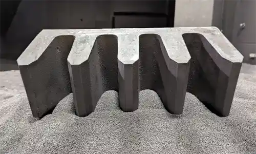 Carbidic austempered ductile iron wall liner with teeth.